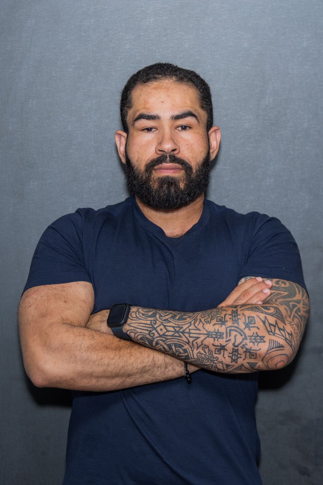 Master Coach Everton Pampa de braços cruzados, em retrato profissional de estúdio